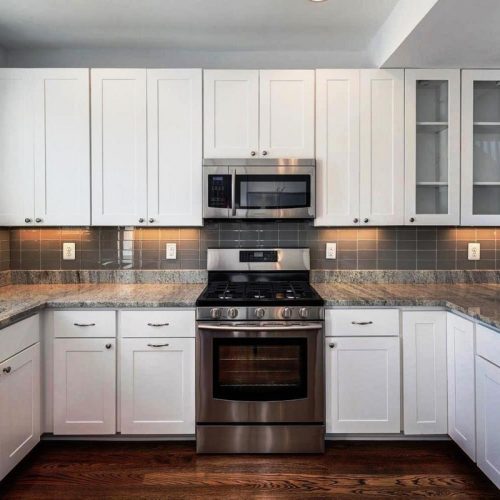white kitchen cabinets with gray granite countertops